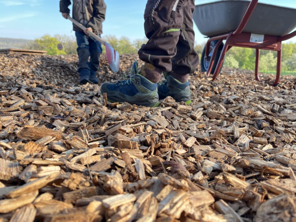 Hackschnitzen mit Schaufel und Scubkarre