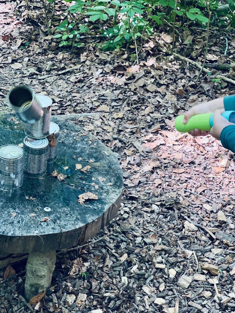Dosen mit Wasserspritzen umschießen
